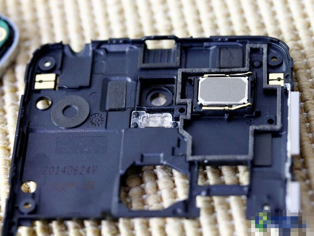 中框内层的设计部分，右侧长方形面积是扬声器单元，这与一般手机将扬声器设计在手机下方有所不同。如果你看上一张图的话，会发现主板相应部分有一处同等大小的空缺，这就是中框扬声器卡扣在主板上的部位。除了扬声器单元，闪光灯灯罩也可看到。