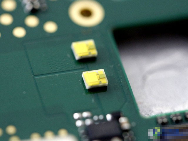 这两个小黄点是什么东西？它们正是联想手机A8的双闪光灯。可能有人第一次见到闪光灯的内部样子。你应该还没有忘记前面中框闪光灯灯罩的图片吧，把灯罩加上之后，就成了我们平常看到的闪光灯整体。